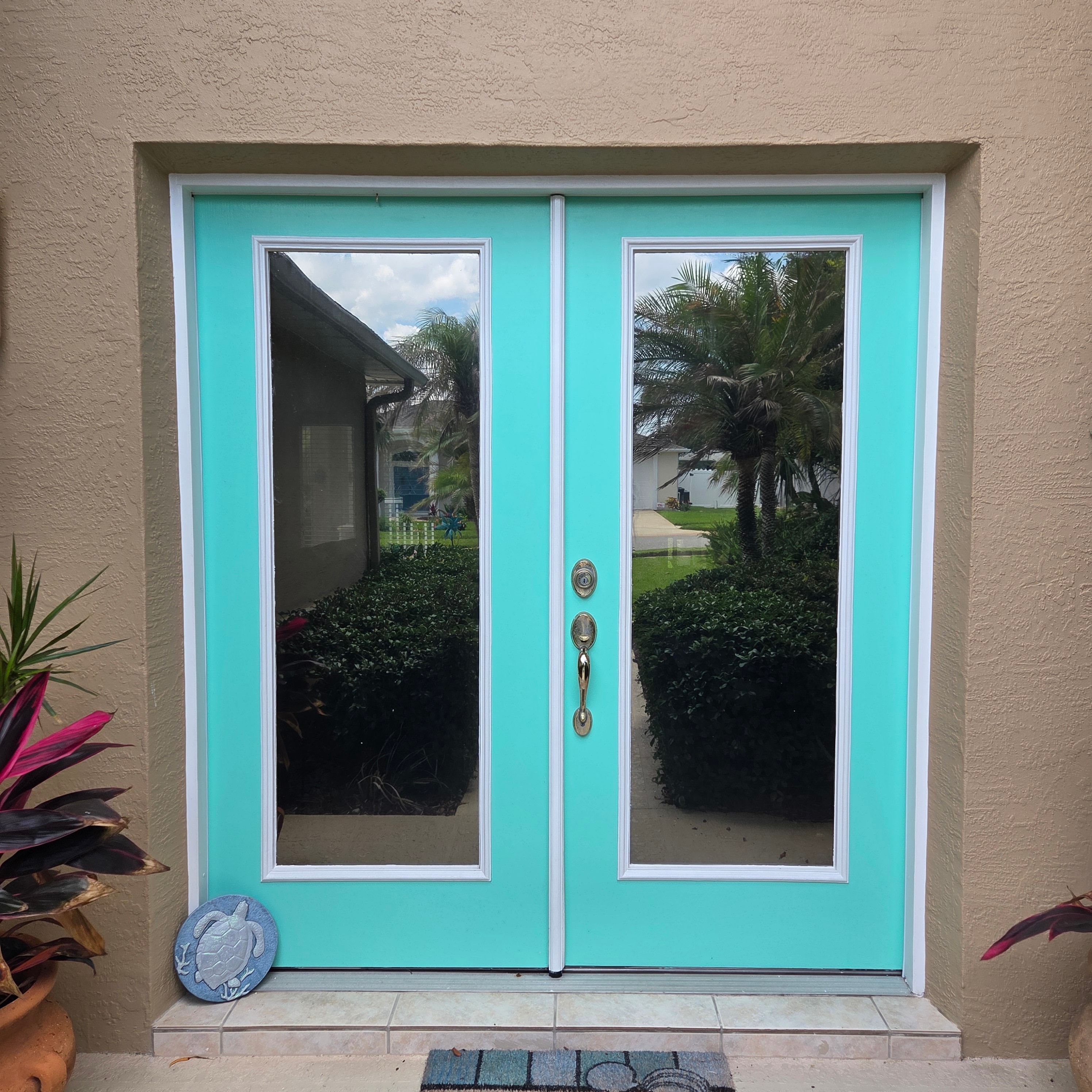 Architectural film on a tropical entrance — turquoise double doors